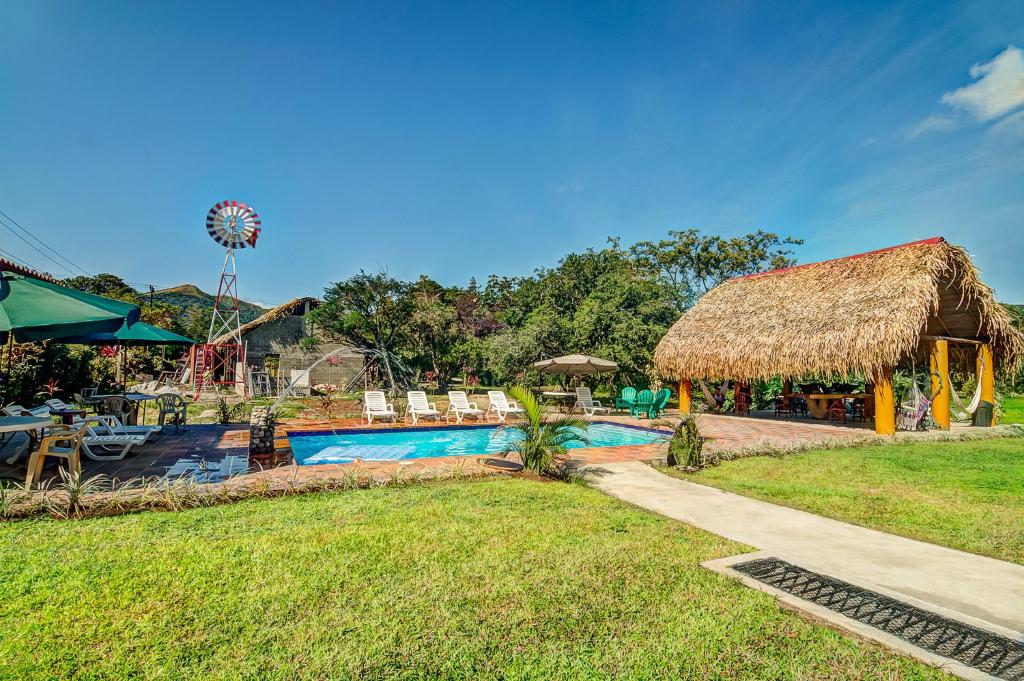 un complexe avec une piscine et un toboggan dans l'établissement Windmill Hostal, à El Valle de Antón