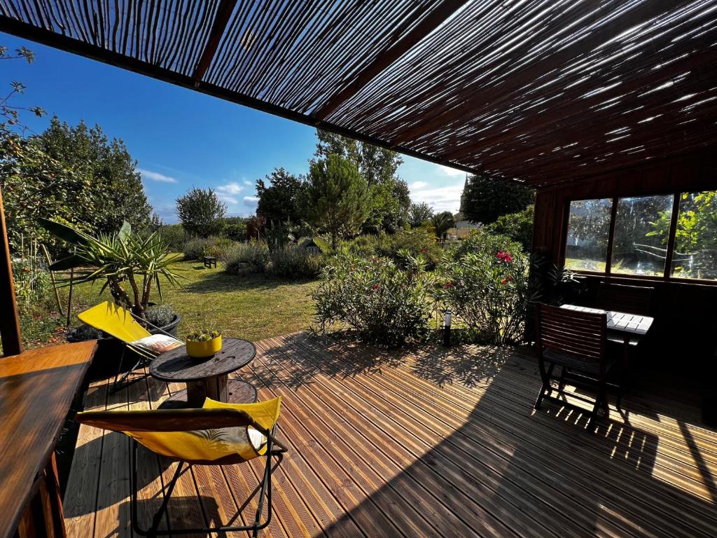 a patio with a table and chairs on a wooden deck at Chalet Ecolodge Mazion in Mazion