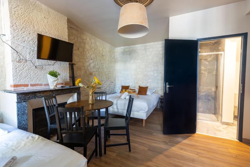 une chambre avec un lit et une table et une chambre avec deux lits dans l'établissement L'Authentic, à Saint-Aignan