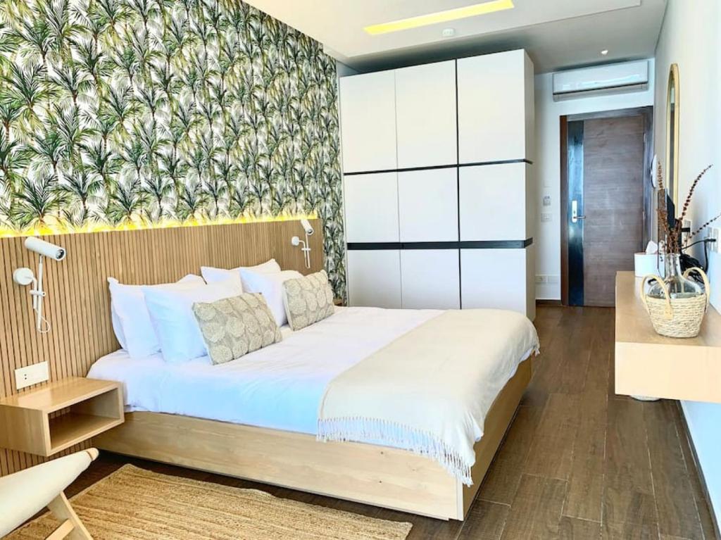 een slaapkamer met een groot bed en een muurschildering bij Majestic Palm Beachfront Exotic Room in Batroun 