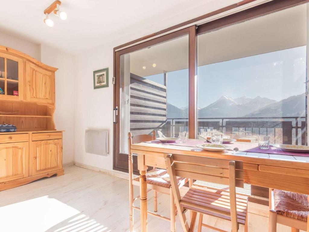 une cuisine avec une table et des chaises ainsi qu'une grande fenêtre dans l'établissement Grand studio calme 5 pers, parking, balcon, Briançon - FR-1-330C-88, à Briançon
