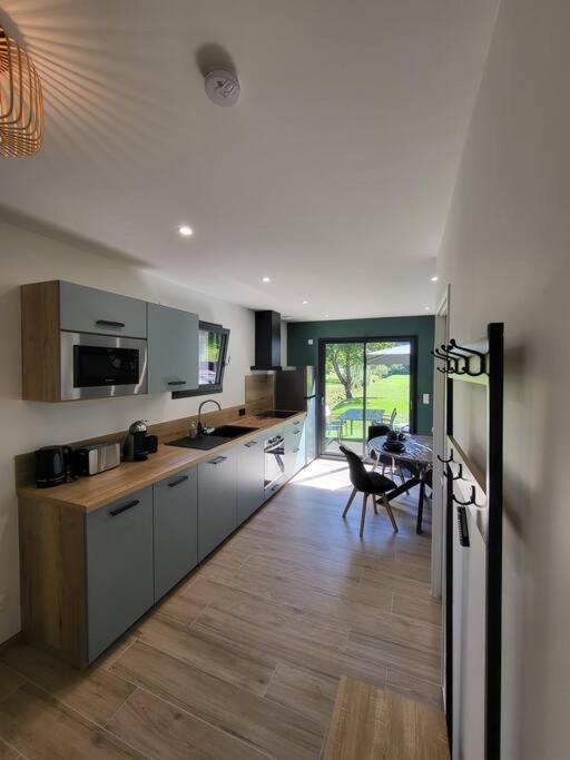 une cuisine avec une table et une salle à manger dans l'établissement Maison au coeur des montagnes de l'Oisans, à Le Bourg d'oisans