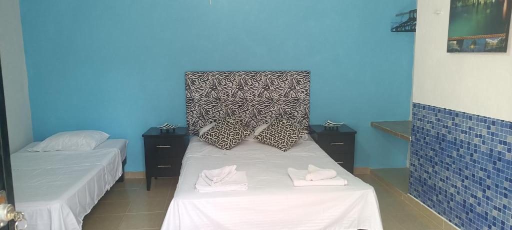 Habitación con 2 camas y pared azul en Apartamento ideal y acogedor en Mérida