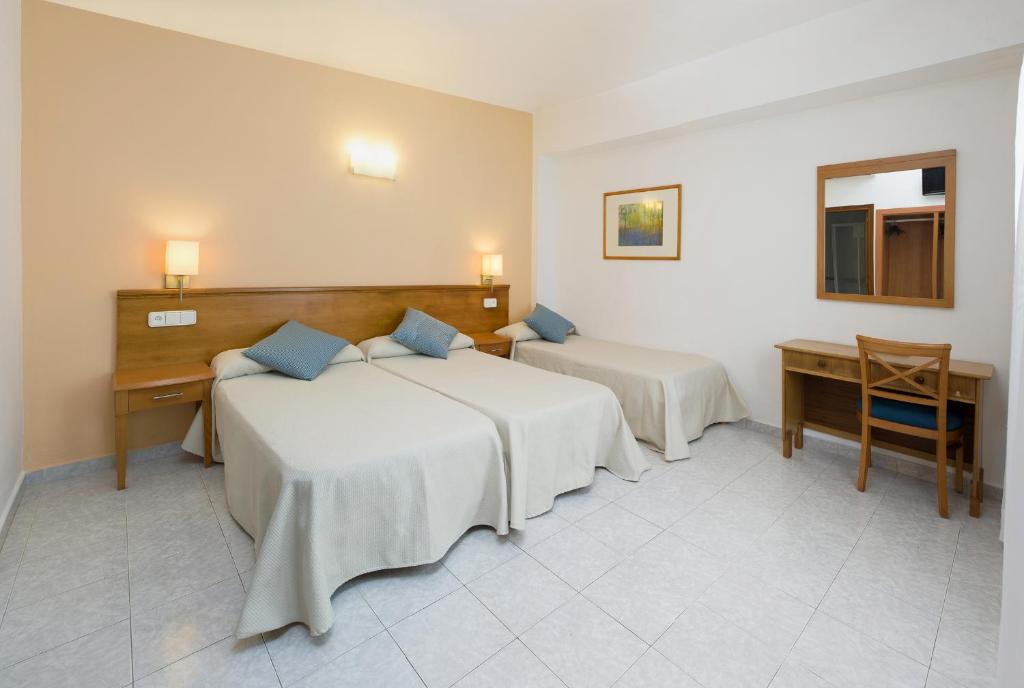 A bed or beds in a room at Hostal Mallorca