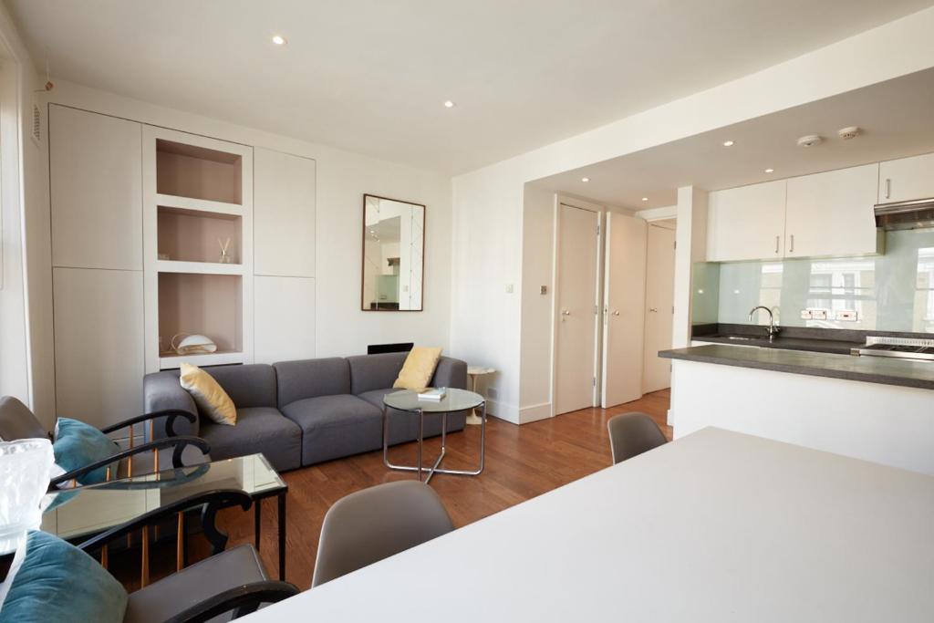 a living room with a couch and a kitchen at Notting Hill, Portobello, Kensington Chelsea in London