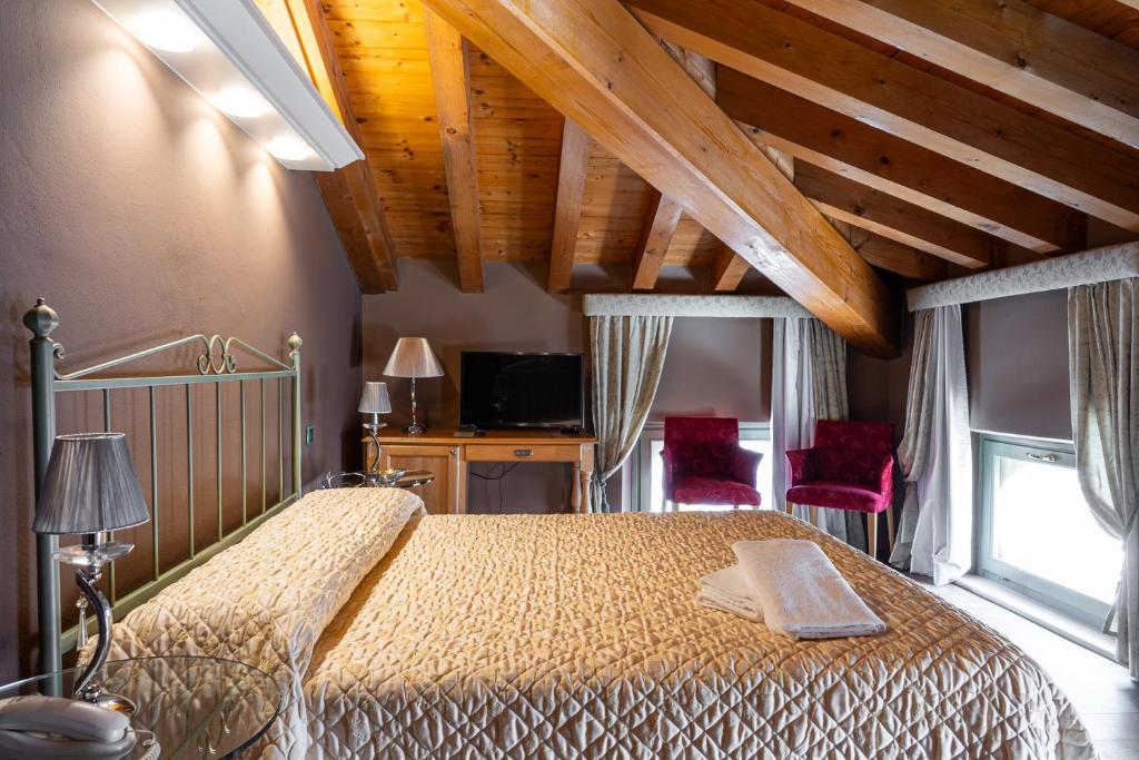 1 dormitorio con 1 cama y 2 sillas rojas en Residenza Villa Vecelli Cavriani, en Mozzecane