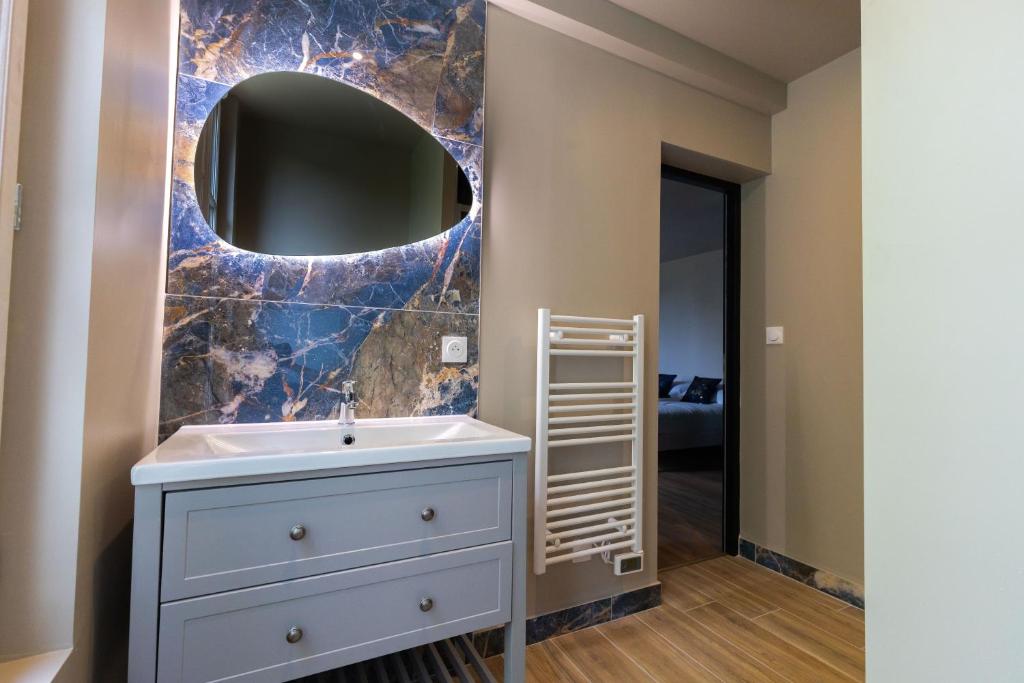 uma casa de banho com um lavatório e um espelho em L'Agate Bleue em Saint-Aignan