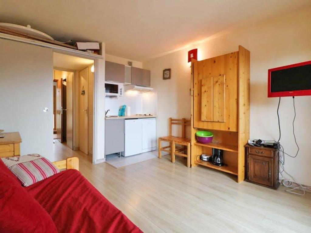 ラ・ロジエールにあるStudio Montvalezan-La Rosière, 1 pièce, 4 personnes - FR-1-398-572のリビングルーム(赤いベッド1台付)、キッチンが備わります。