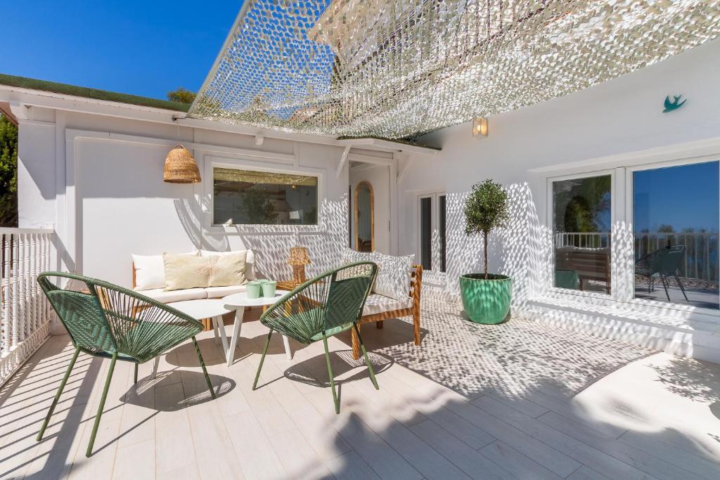 un patio con sillas, una mesa y un sofá en Casa de la Playa. Beach House with magnificent sea, en Málaga