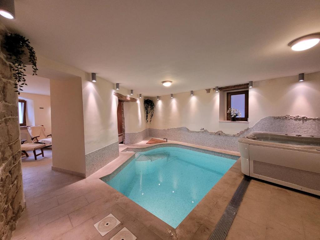 a large swimming pool in a room with a couch at Casa Acqua Dolce - House with 4 Bedrooms and Own Spa in Oprtalj