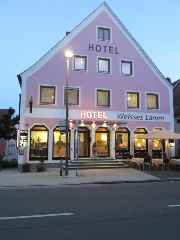 ein großes Gebäude mit einem Hotel an der Straßenseite in der Unterkunft Hotel Weisses Lamm in Allersberg