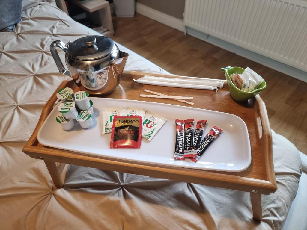a tray with a tea pot on a table on a bed at Private room City skyline and mountain views close too belfast centre and airports free parking in Belfast