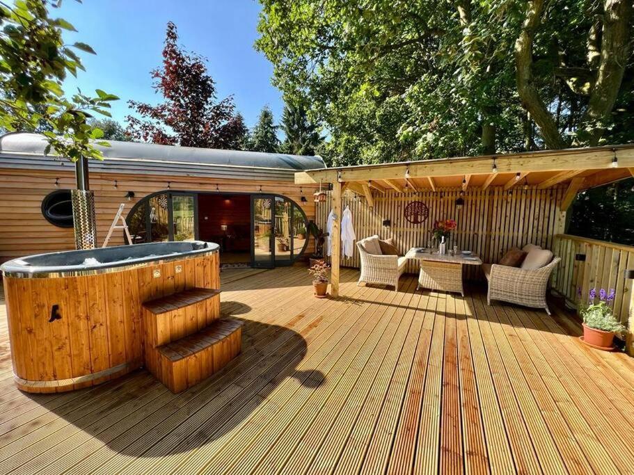 una gran terraza de madera con bañera de hidromasaje. en The Pines Treehouse at Treetops Hideouts, en Richmond