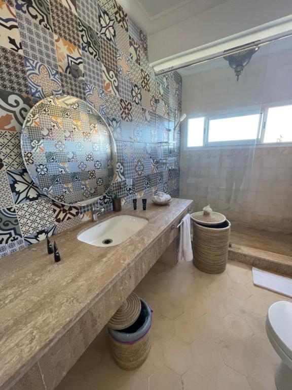 a bathroom with a sink and a toilet at Villa La Falaise in Oualidia