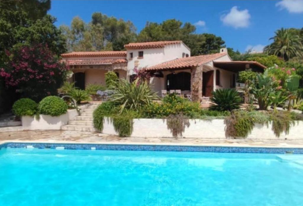 uma casa com piscina em frente a uma casa em Villa La Louvière La Croix Valmer Golfe de Saint Tropez em La Croix-Valmer