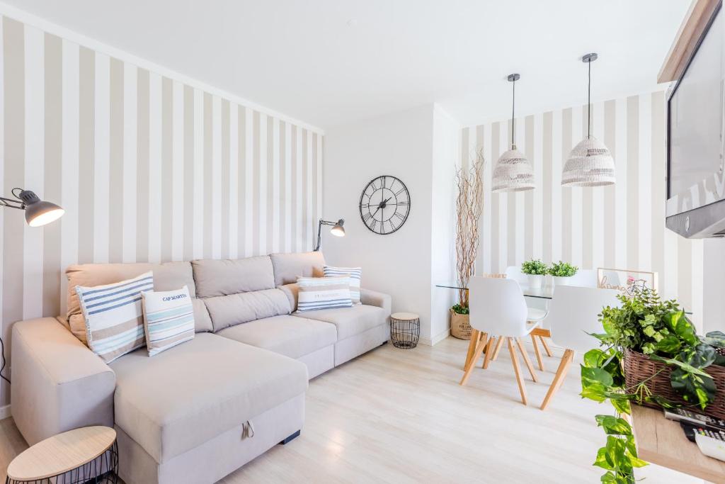 a living room with a white couch and a table at Alfamar Apartment at Praia da Falesia in Albufeira