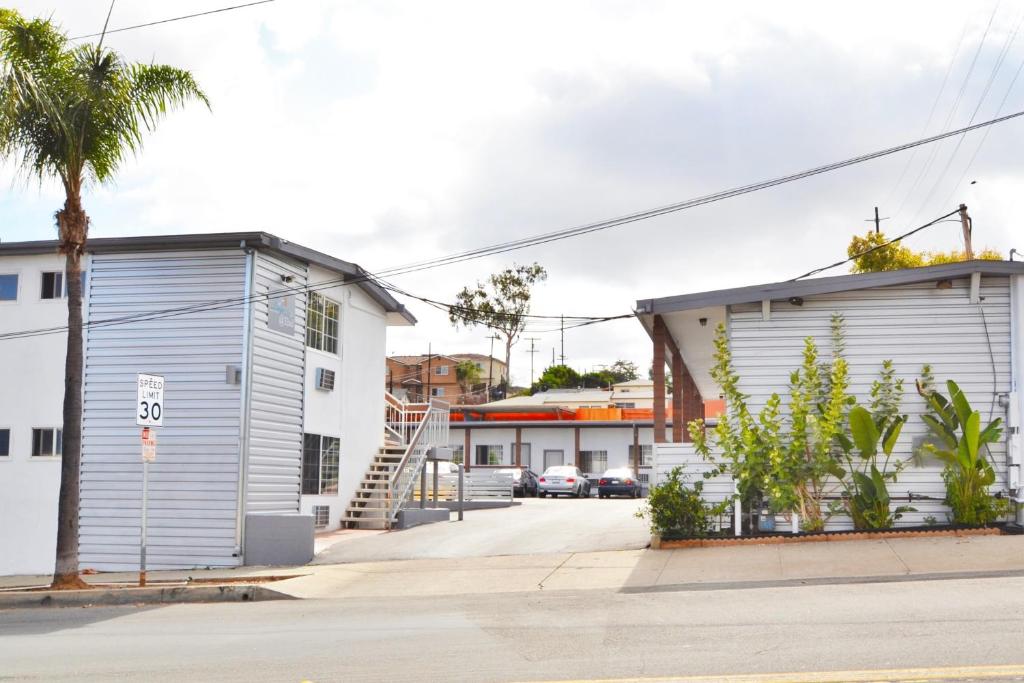 a street with two buildings and a palm tree at Lodge at 32nd in San Diego