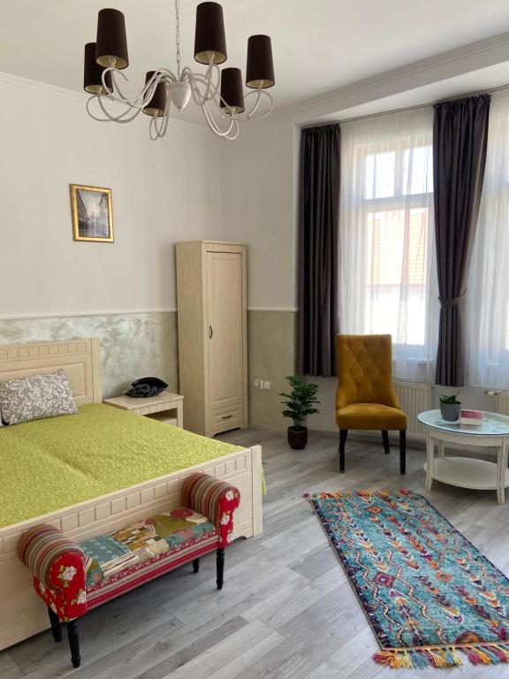 ein Schlafzimmer mit einem grünen Bett und einem Stuhl in der Unterkunft Penzión Bihari in Dunajská Streda