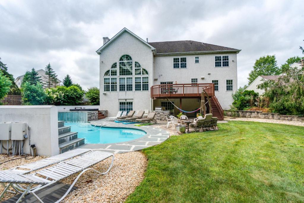 un patio trasero con piscina y una casa en Centrally Located Harleysville Home with Pool, en Harleysville
