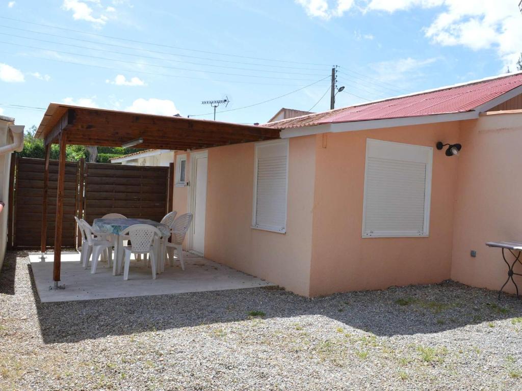 un patio avec une table et des chaises devant une maison dans l'établissement Maison proche plage et commerces, 3 pièces, climatisée, 6 couchages, animaux acceptés - FR-1-229D-57, à Fleury