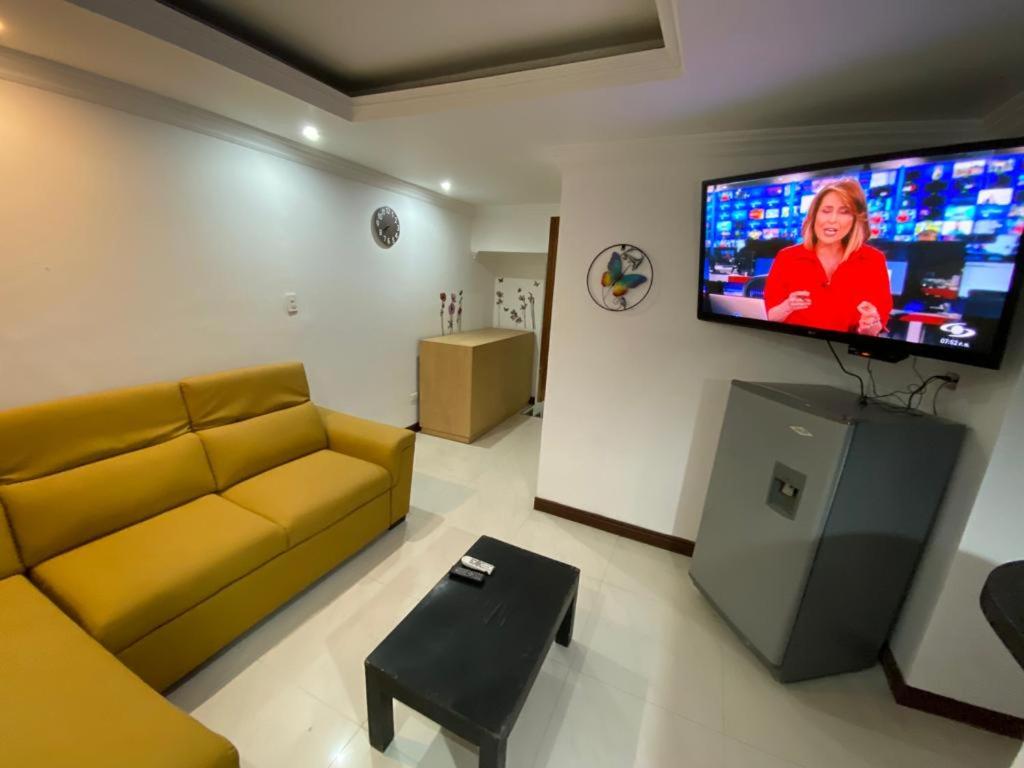 sala de estar con sofá y TV de pantalla plana en apartamento poblado, en Medellín