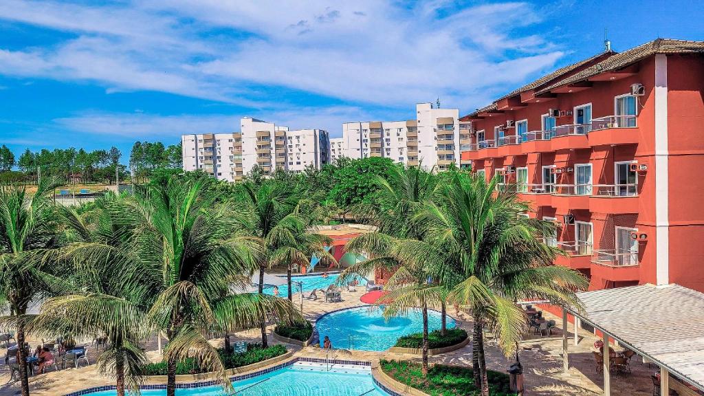 an aerial view of a resort with a pool and palm trees at Frente ao Parque da Lagoa Quente Entrada NÃO INCLUSA Aptos Particulares com varanda in Caldas Novas