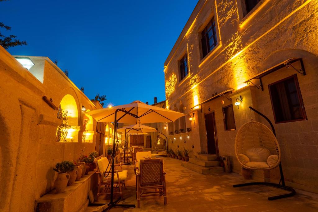 an alley with tables and chairs and an umbrella at CAPPANAR CAVE HOTEL in Nar