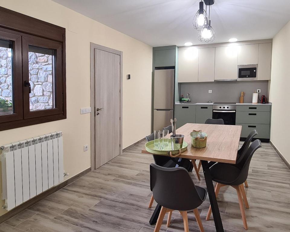 a kitchen and dining room with a table and chairs at Apartamentos La Era de Pasé in Sopeira