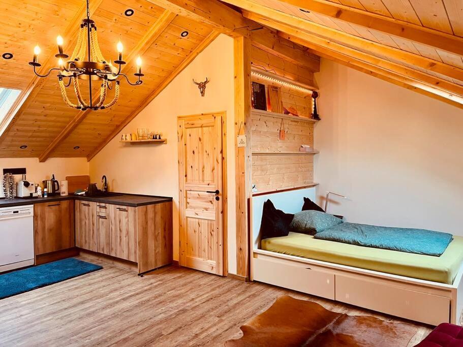 a kitchen with a bed in a room with a chandelier at VIP Suite - Game Changer Hof in Eging am See