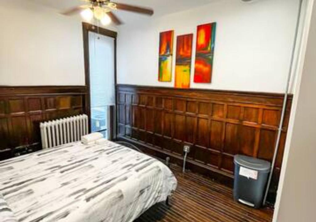 Schlafzimmer mit einem Bett und Wandmalereien in der Unterkunft Legacy - Spring Garden University City in Philadelphia