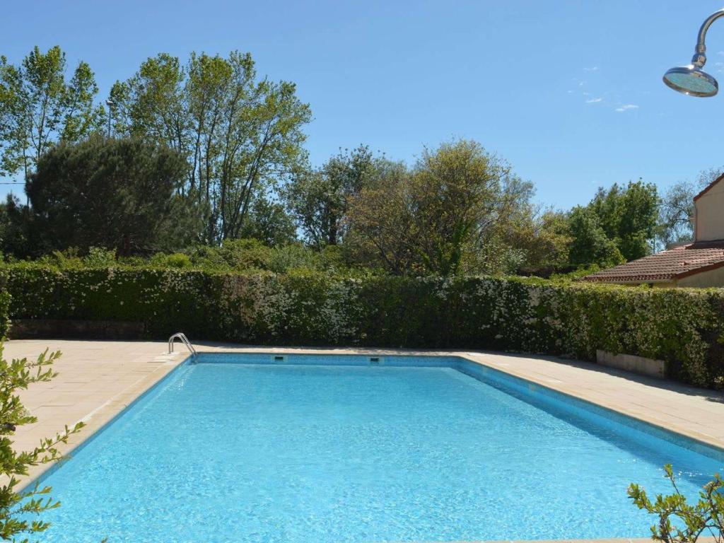 - une piscine dans une cour avec une haie dans l'établissement Charmant T2 Mezzanine avec Piscine à Port Cogolin – 6 Couchages, Parking Privatif, Proche Plages - FR-1-226B-39, à Cogolin