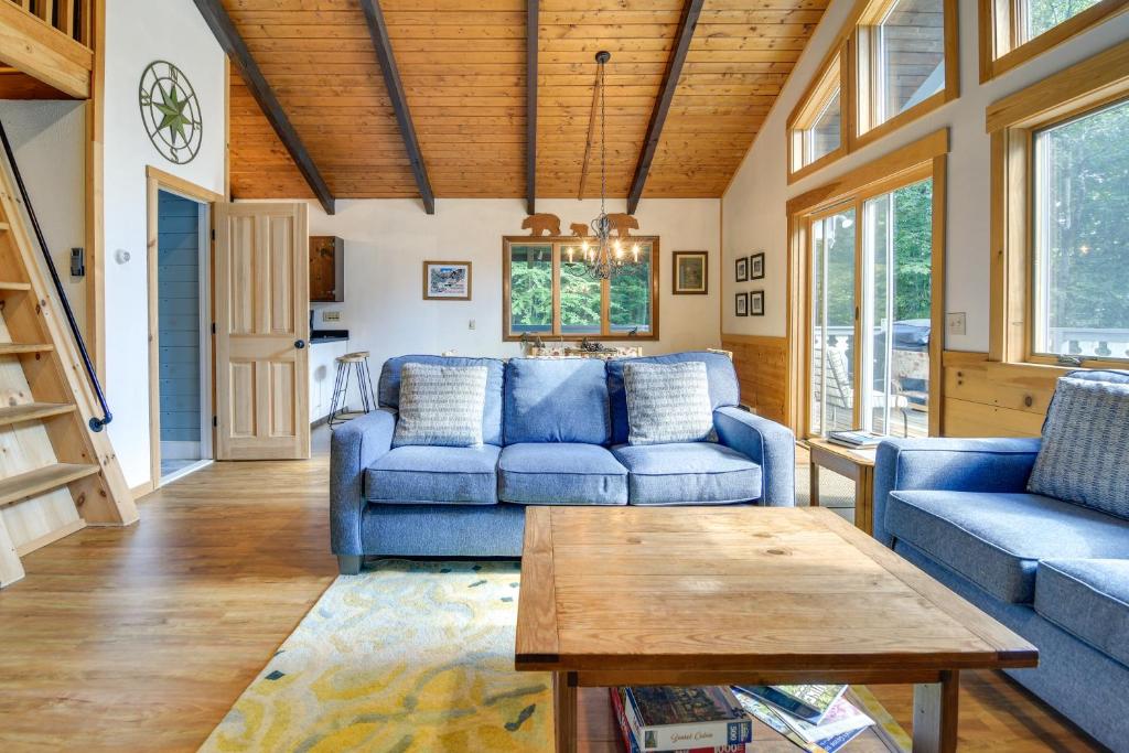 uma sala de estar com sofás azuis e uma mesa em Beautiful Chalet about 5 Miles to Attitash Mountain em Glen