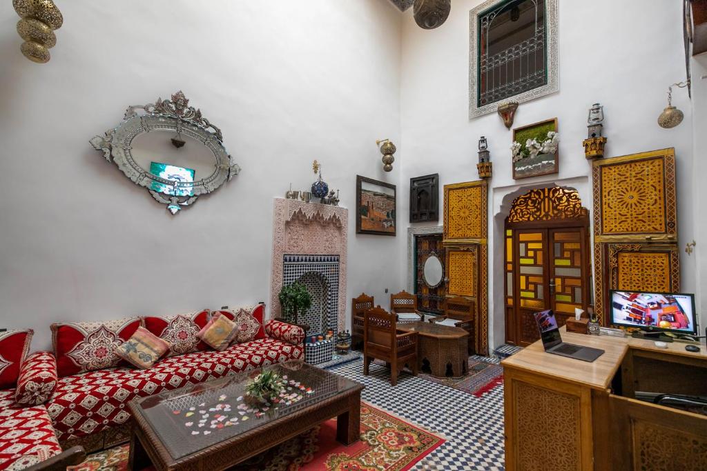 sala de estar con sofá y TV en Riad Fes Allouch, en Fez
