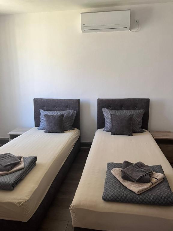 two beds sitting next to each other in a room at Sobe Šponga 4, in Kikinda