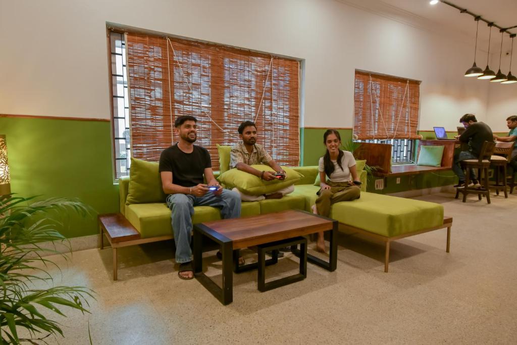 a group of people sitting on a couch in a room at Snore Summore, Hostel in Koramangala in Bengaluru