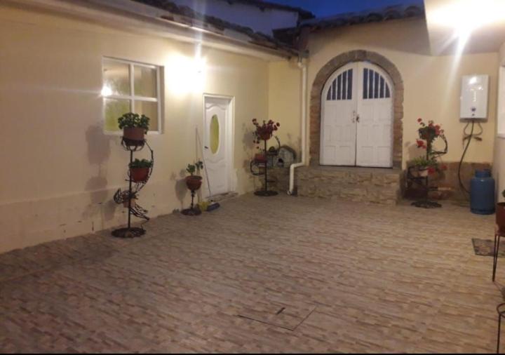 a large room with a white door and potted plants at El Andarin Home Stay in El Ángel