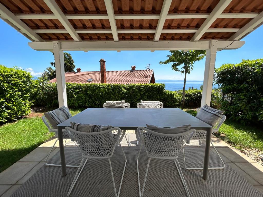 einen Tisch und Stühle auf einer Terrasse mit einer Pergola in der Unterkunft Vila Ester - apartman Lovrana in Lovran