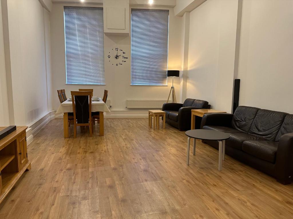 een woonkamer met een bank en een tafel bij City Centre 3 bedrooms apartment with parking in Nottingham