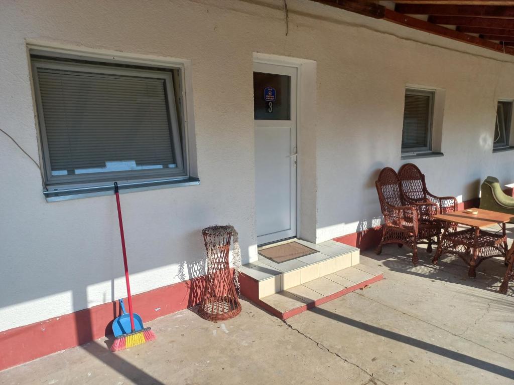 a porch of a house with a table and chairs at Apartman ALEXANDAR in Bogatić