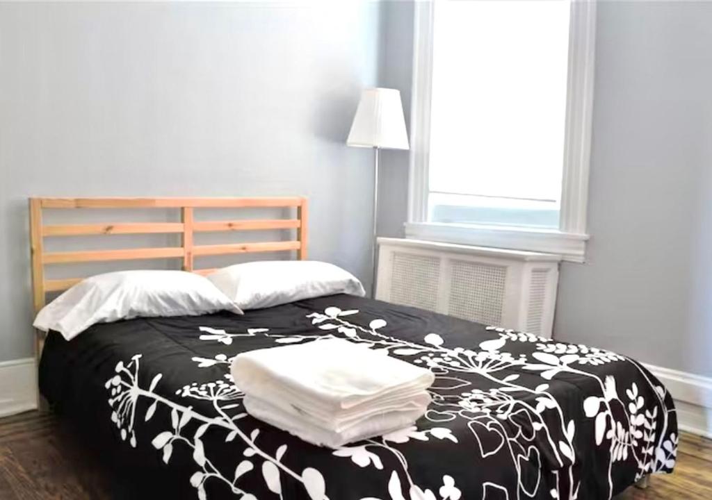 a bedroom with a black and white bed with towels on it at Clover 2900 - Apartment and Rooms with Private Bathroom near Washington Ave South Philly in Philadelphia