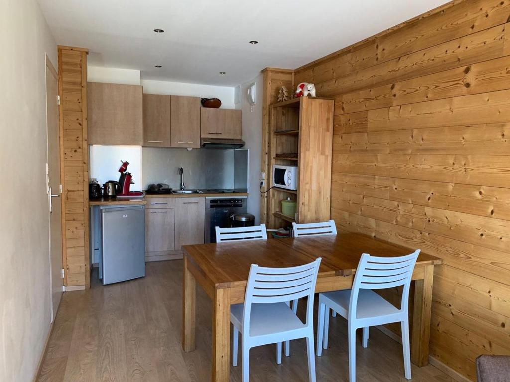 uma cozinha com uma mesa de madeira e cadeiras em Appartement Huez, 3 pièces, 6 personnes - FR-1-405-172 em Alpe-dʼHuez
