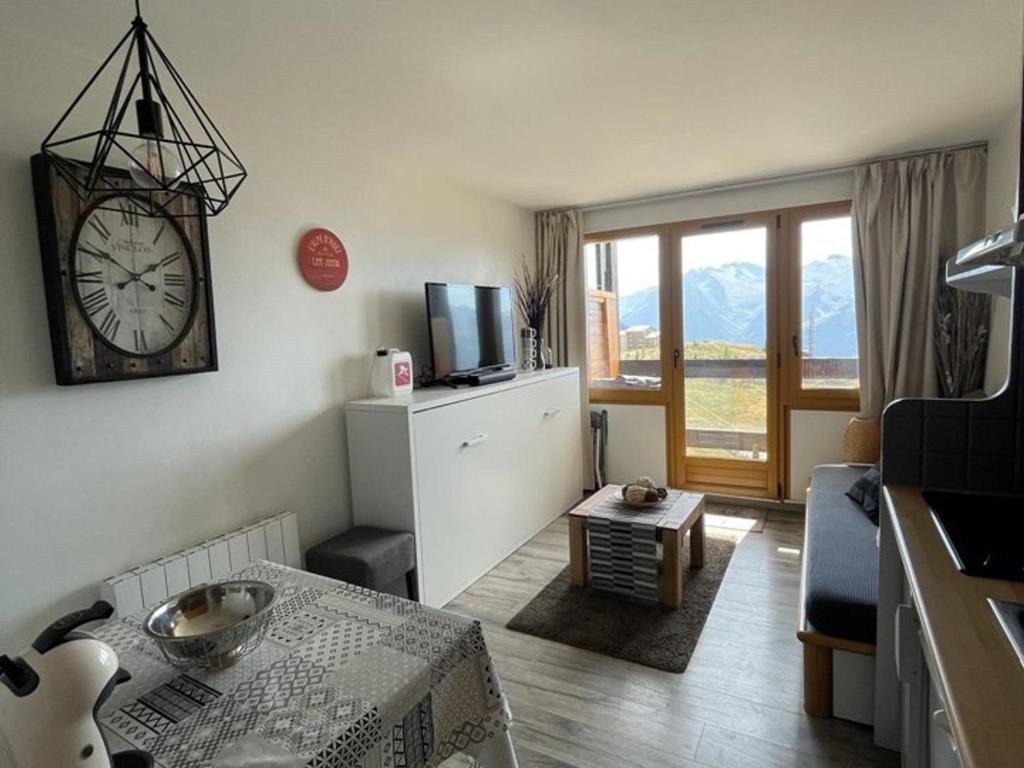 ein Wohnzimmer mit einer Uhr an der Wand in der Unterkunft Appartement Huez, 2 pièces, 4 personnes - FR-1-405-173 in L'Alpe-d'Huez