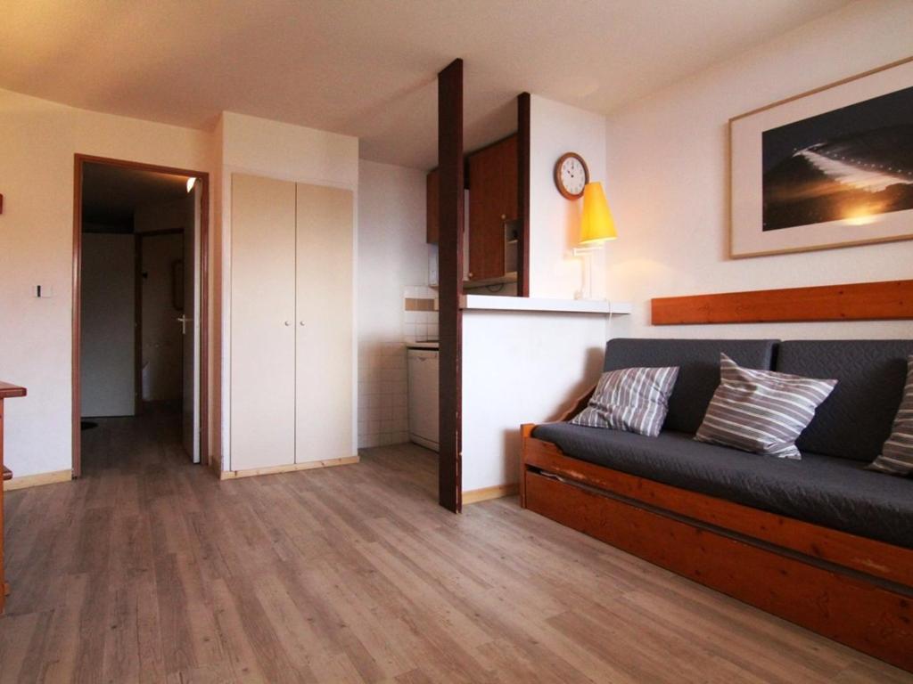 un salon avec un canapé et une cuisine dans l'établissement Appartement cosy 2 pièces, balcon, 6 pers. - Alpe d'Huez, proche pistes et commerces - FR-1-405-174, à L'Alpe-d'Huez