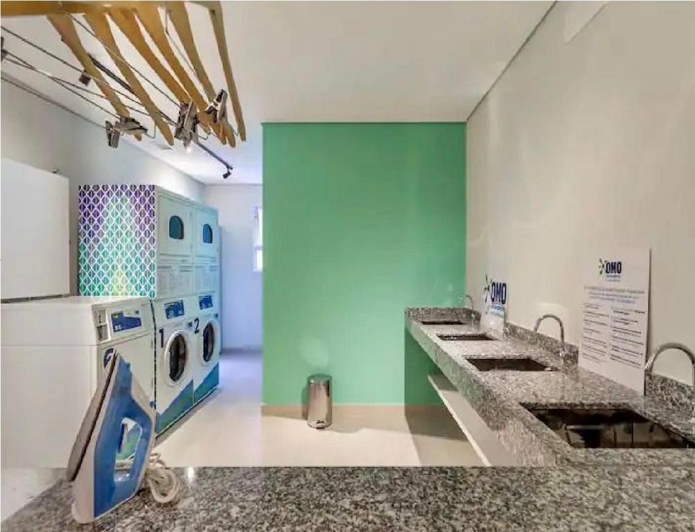 a kitchen with a washing machine and a washer and dryer at Incrível Apartamento Em Frente Ao Metrô Brás ! in Sao Paulo