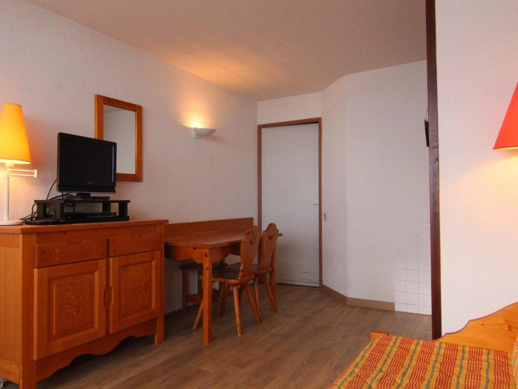 a room with a desk with a computer and a bedroom at Appartement Huez, 1 pièce, 4 personnes - FR-1-405-183 in LʼHuez