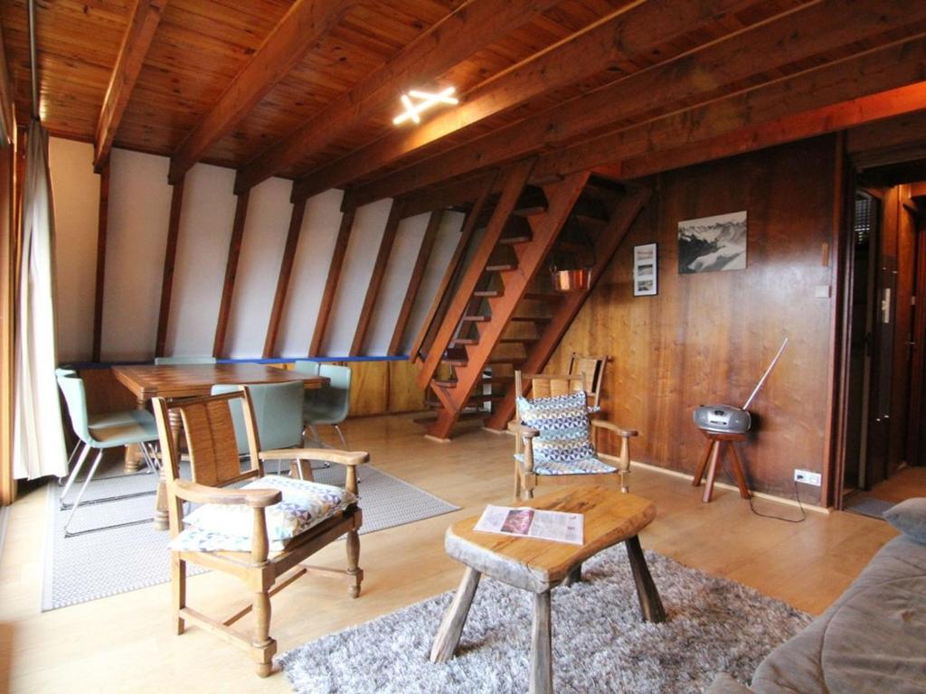 a living room with chairs and a table and stairs at Chalet Huez, 3 pièces, 6 personnes - FR-1-405-184 in LʼHuez