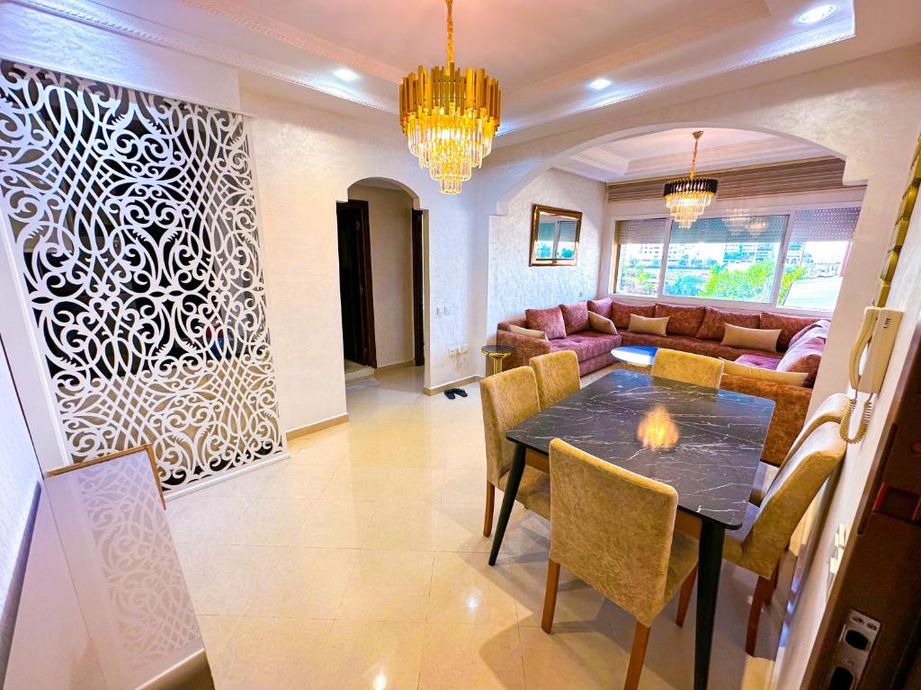 un soggiorno con tavolo e divano di LovelyStay - Luxury & proximity to Corniche and TGV a Tangeri
