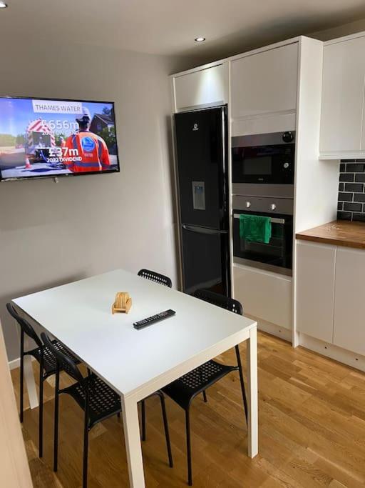 a kitchen with a white table and two chairs and a kitchen with a refrigerator at Garland way 2 bed house Sheffield free parking 5 min from m1 in Mosborough