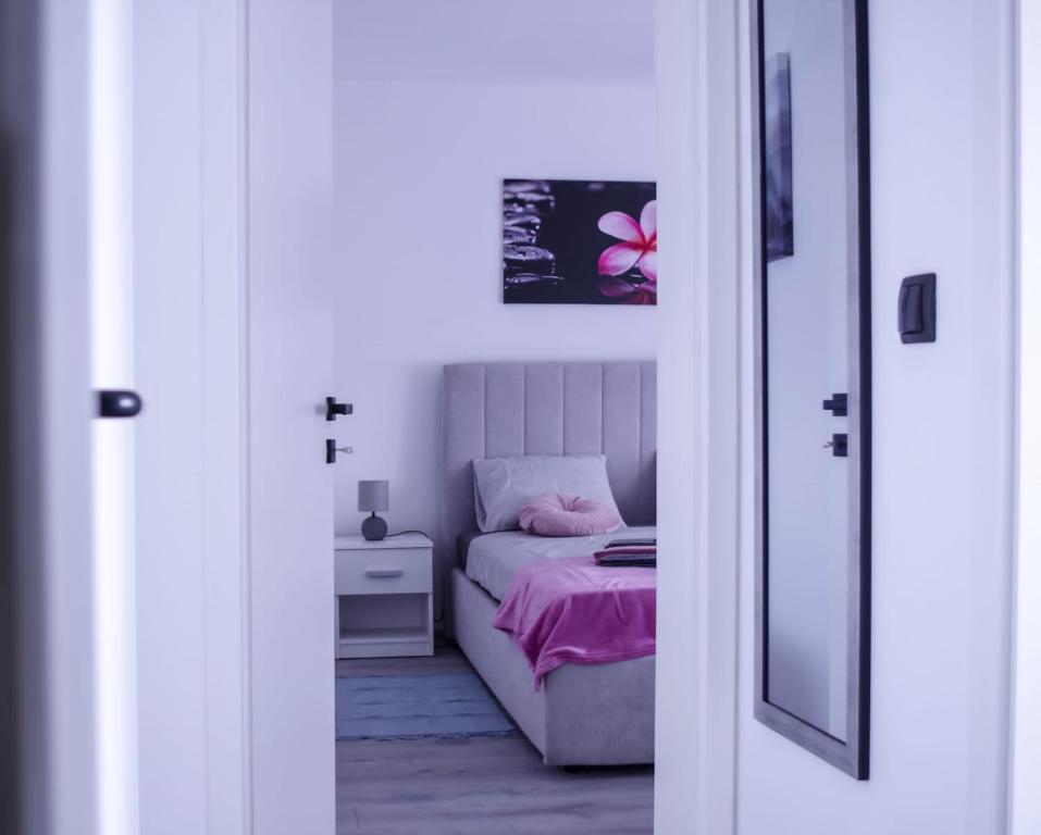札格雷布的住宿－North&South Apartments，小卧室配有一张带粉色毯子的床