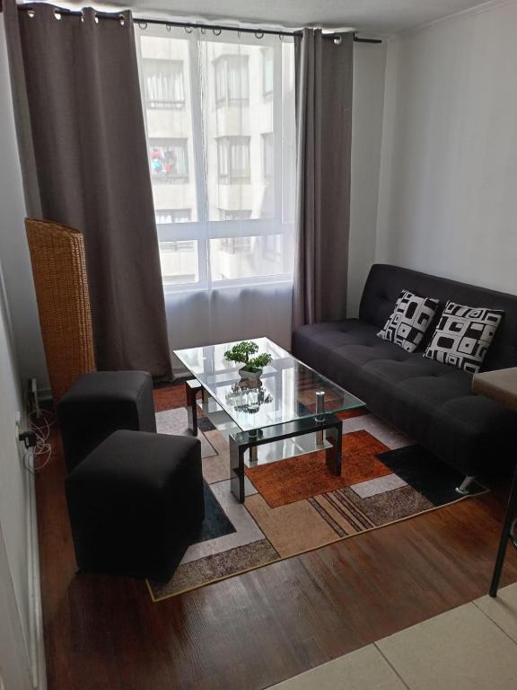 uma sala de estar com um sofá e uma mesa de vidro em santiago centro em Santiago